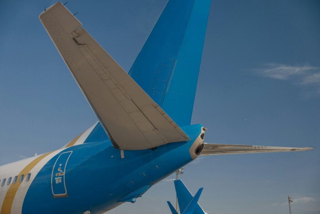 Tail of an aircraft in airport with blue sky in the background